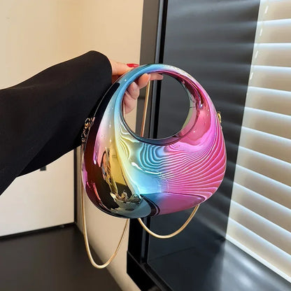 Multicolored handbag held by a person against a neutral background