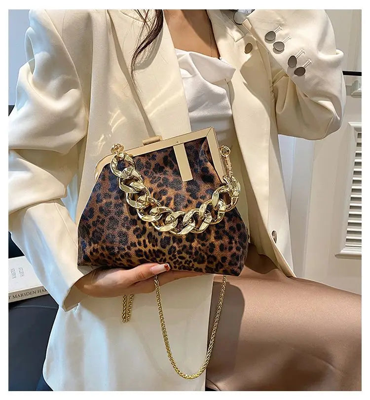 Carauana_UNIU_Leopard_Clutch with gold chain held by a person wearing a white outfit.