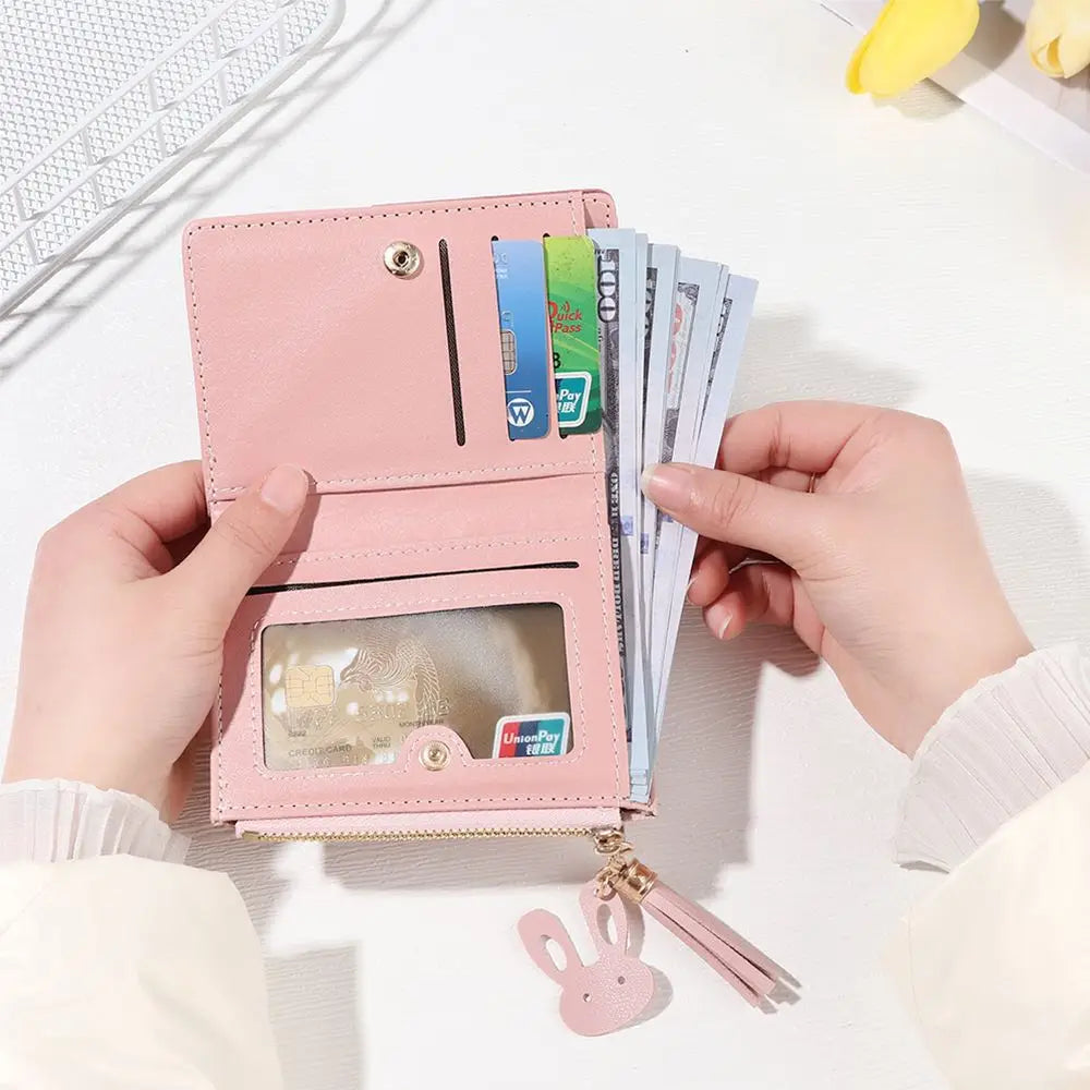 Pink wallet with card slots and money held by hands on a white background