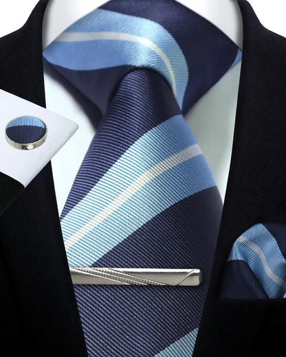 Navy and light blue striped tie with matching pocket square and tie clip on a white shirt.