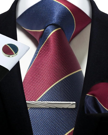 Maroon and blue striped tie with a silver tie clip on a white shirt.