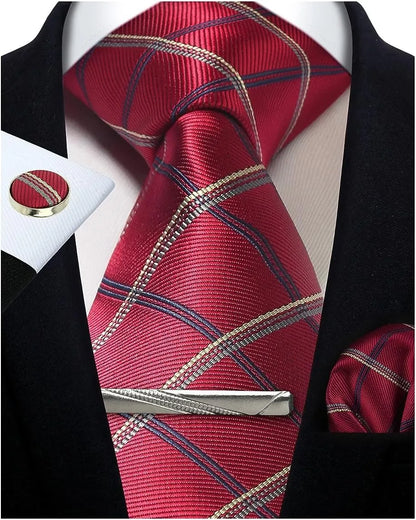 Red plaid tie with gold accents, matching pocket square, and tie clip on a black suit jacket.